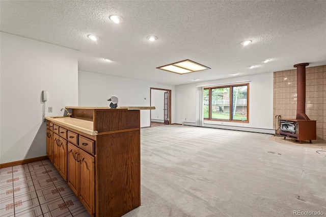 7351 Poppy Way, Arvada, CO 80007 - bar area featuring baseboard heating, a textured ceiling, a wood stove, recessed lighting, and light colored carpet