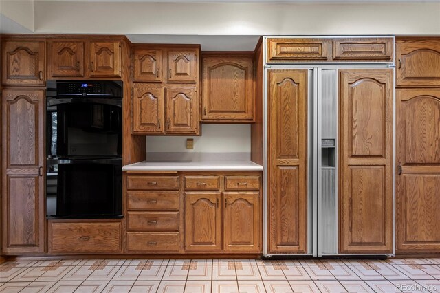 7351 Poppy Way, Arvada, CO 80007 - kitchen featuring paneled built in refrigerator, brown cabinets, and light countertops