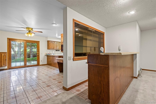 7351 Poppy Way, Arvada, CO 80007 - kitchen with a ceiling fan, brown cabinetry, a textured ceiling, and light countertops