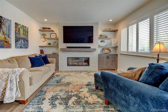 living room with recessed lighting, wood finished floors, and a fireplace