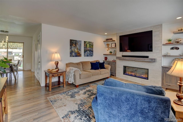 living area featuring light wood-type flooring, recessed lighting, baseboards, and a tile fireplace