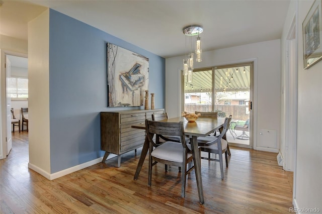 dining space with baseboards and wood finished floors