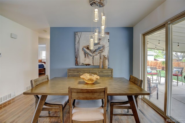 dining space with visible vents, a wealth of natural light, and wood finished floors
