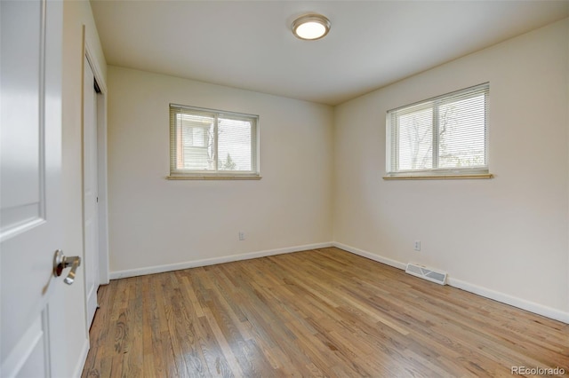 unfurnished bedroom with baseboards, a closet, visible vents, and wood finished floors