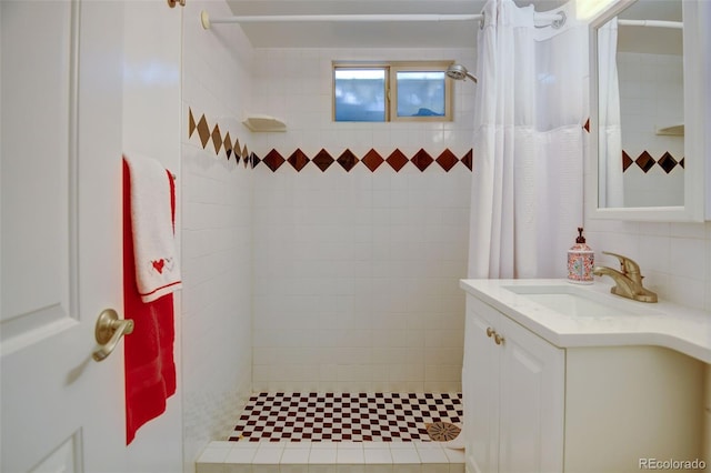 bathroom featuring a tile shower and vanity