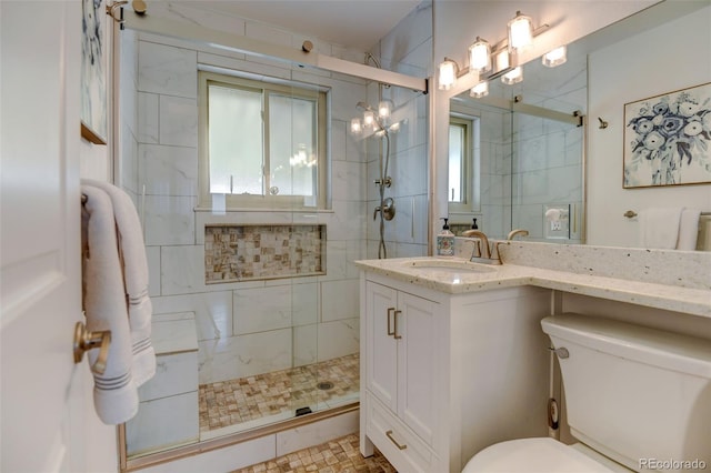 full bath featuring a shower stall, vanity, and toilet