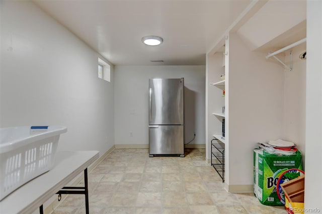 kitchen featuring baseboards and freestanding refrigerator