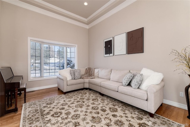 living room with hardwood / wood-style floors, ornamental molding, and a high ceiling