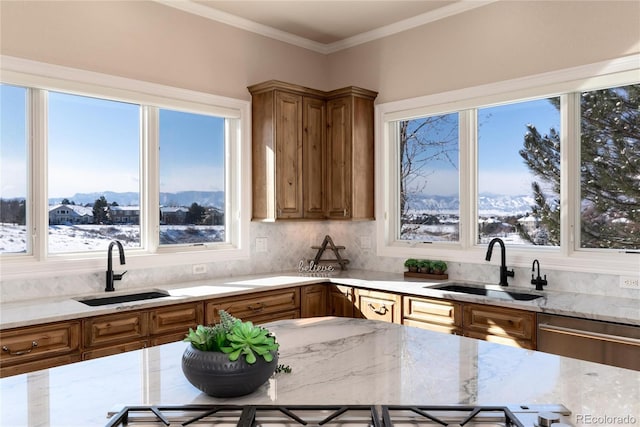 kitchen featuring light stone counters, sink, a mountain view, and stainless steel dishwasher