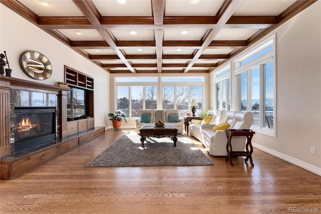 living room featuring beamed ceiling, plenty of natural light, coffered ceiling, and a fireplace