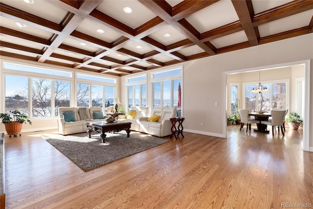 living room featuring beamed ceiling, coffered ceiling, light hardwood / wood-style flooring, and a notable chandelier