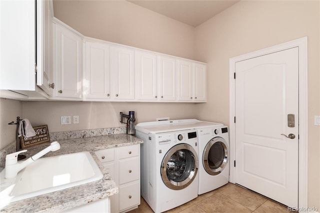 laundry room with cabinets, washer and clothes dryer, sink, and light tile patterned floors