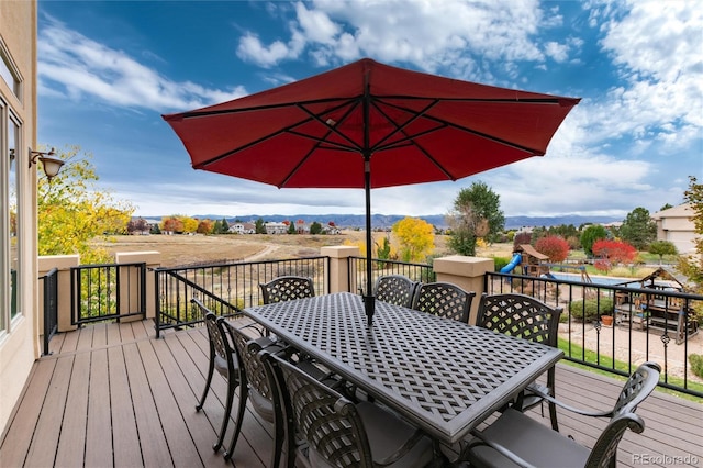 wooden deck with a playground and a mountain view