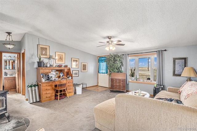 living room featuring vaulted ceiling, carpet, a wood stove, and a textured ceiling