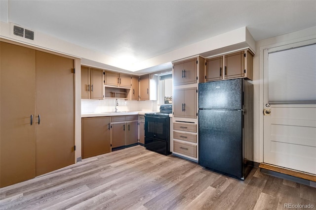 3728 N Vance St Unit 1-4, Wheat Ridge, CO 80033 - kitchen with black appliances, a sink, light wood-type flooring, light countertops, and decorative backsplash