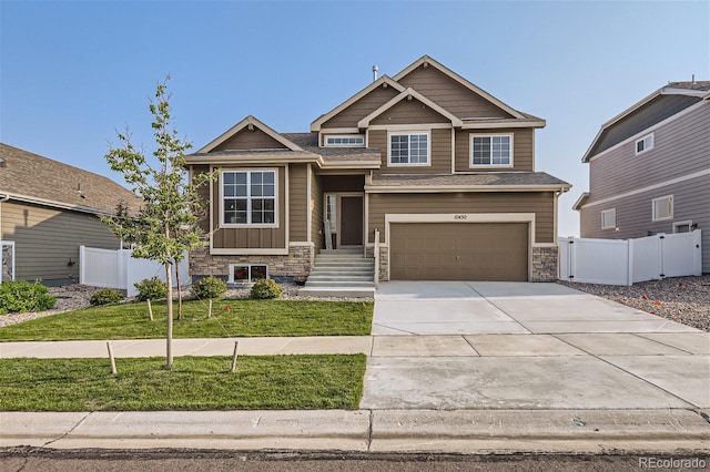 10430 18th St, Greeley, CO 80634 - craftsman-style house featuring stone siding, concrete driveway, a garage, and fence