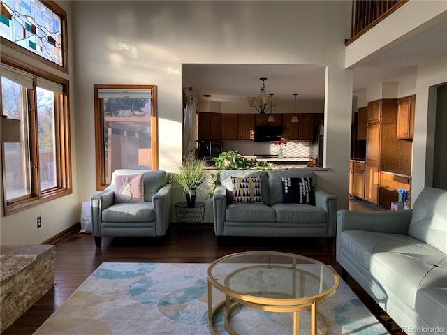 living area featuring a towering ceiling and dark wood-style floors