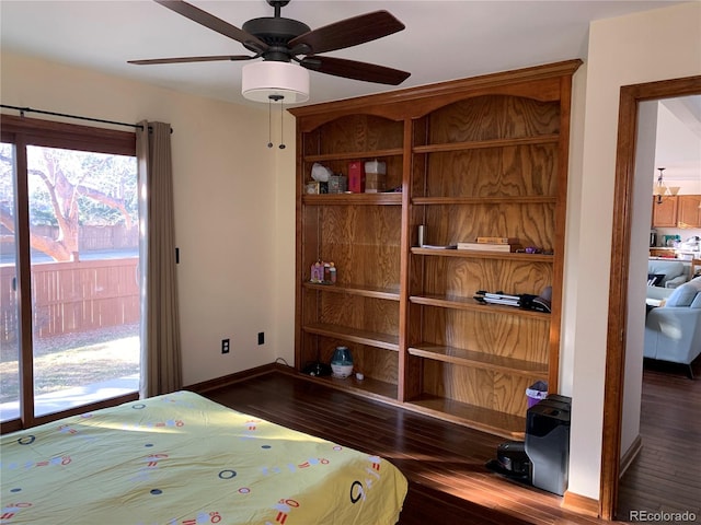 bedroom featuring ceiling fan, baseboards, and wood finished floors