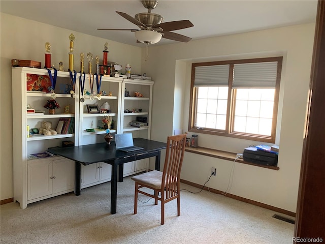 office area with a ceiling fan, light carpet, visible vents, and baseboards