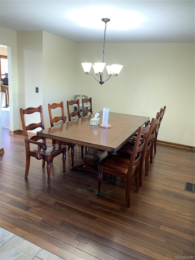 dining room with baseboards, visible vents, a chandelier, and hardwood / wood-style floors