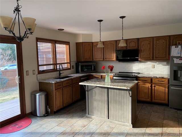 kitchen featuring decorative backsplash, light stone counters, appliances with stainless steel finishes, range hood, and a sink