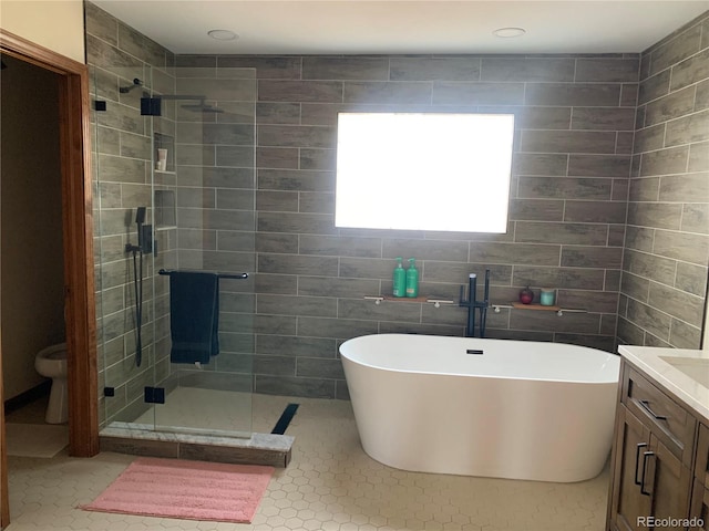 bathroom featuring a soaking tub, tile patterned flooring, a shower stall, and vanity