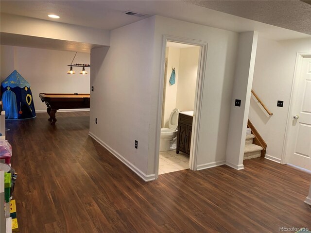 interior space with baseboards, stairs, visible vents, and wood finished floors