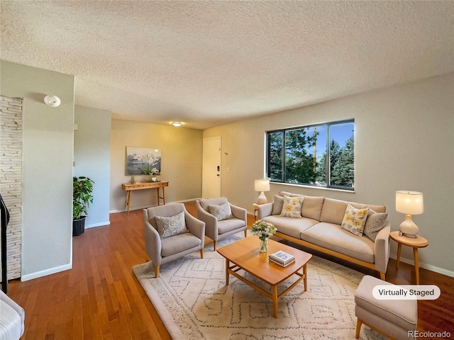 living room featuring wood-type flooring and a textured ceiling