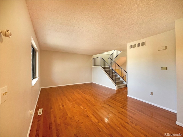 spare room with wood-type flooring and a textured ceiling