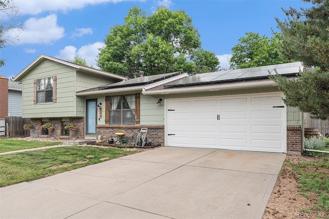 309 S 30th Ave, Brighton, CO 80601 - split level home featuring brick siding, driveway, an attached garage, and roof mounted solar panels