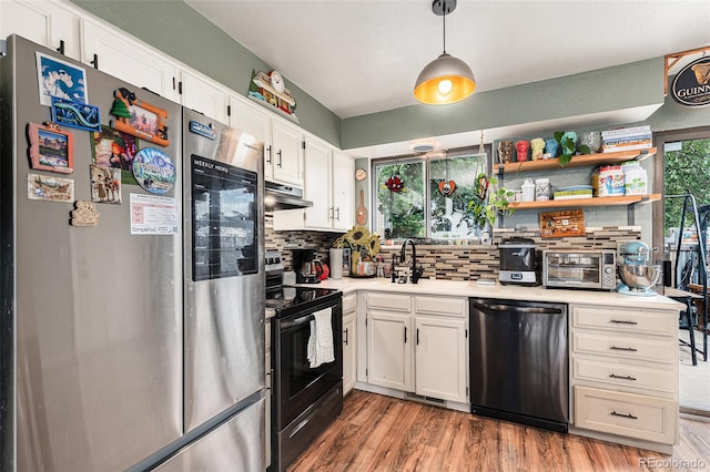 309 S 30th Ave, Brighton, CO 80601 - kitchen featuring appliances with stainless steel finishes, light countertops, backsplash, exhaust hood, and light wood-style floors