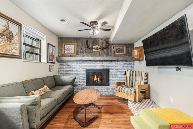 309 S 30th Ave, Brighton, CO 80601 - living area featuring ceiling fan, wood finished floors, a brick fireplace, and a textured ceiling