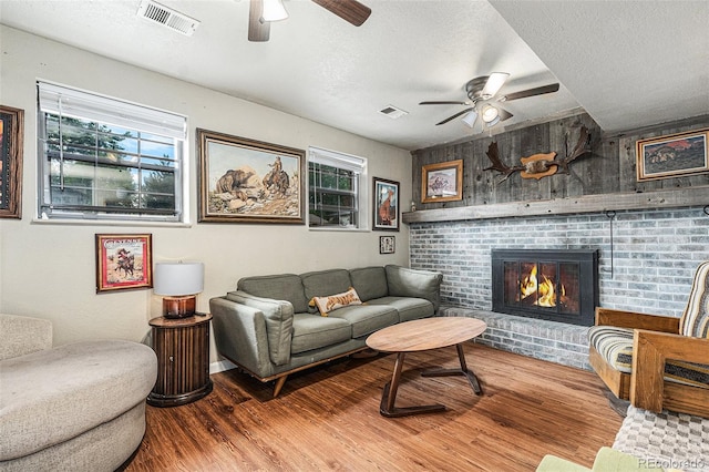 309 S 30th Ave, Brighton, CO 80601 - living room with ceiling fan, wood finished floors, a textured ceiling, and a brick fireplace