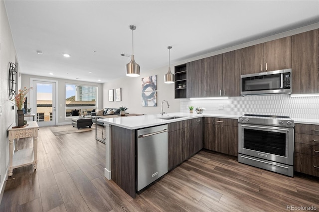 kitchen featuring stainless steel appliances, light countertops, a sink, and open shelves