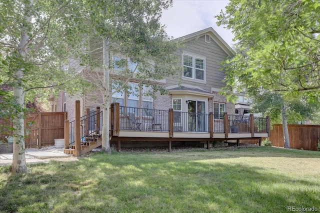 back of house featuring a deck and a yard