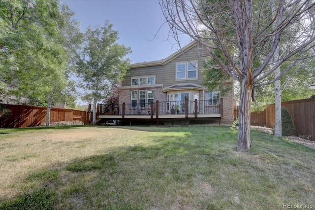 rear view of property with a wooden deck and a yard