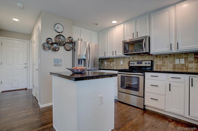 kitchen featuring decorative backsplash, a kitchen island, dark wood-type flooring, white cabinetry, and appliances with stainless steel finishes