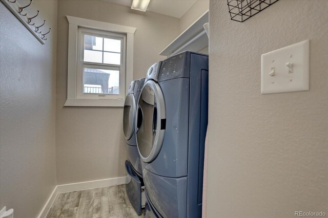 laundry area featuring light wood-type flooring and separate washer and dryer