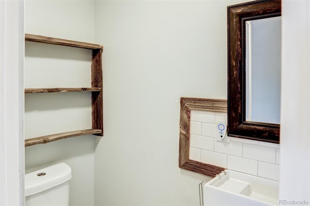 bathroom featuring tasteful backsplash and toilet