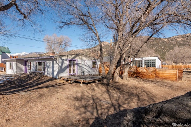 back of property with a deck with mountain view