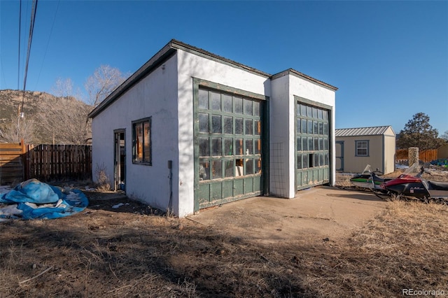 rear view of property featuring a garage and an outdoor structure