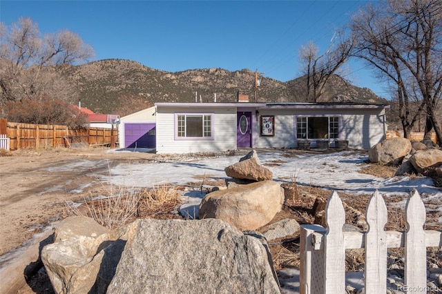 view of front facade featuring a chimney, fence, and a mountain view
