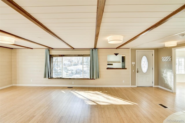 entrance foyer featuring beamed ceiling, visible vents, wood finished floors, and baseboards