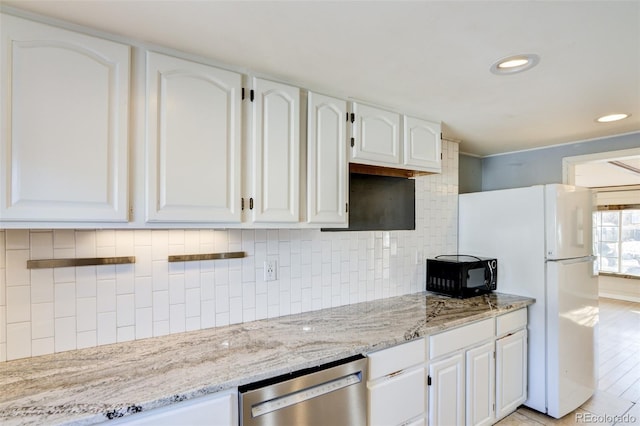 kitchen featuring dishwasher, tasteful backsplash, white cabinetry, black microwave, and freestanding refrigerator