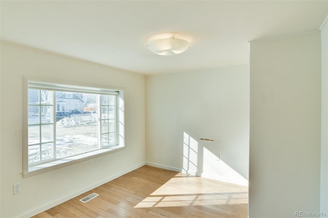 unfurnished room with light wood-style flooring, baseboards, and visible vents