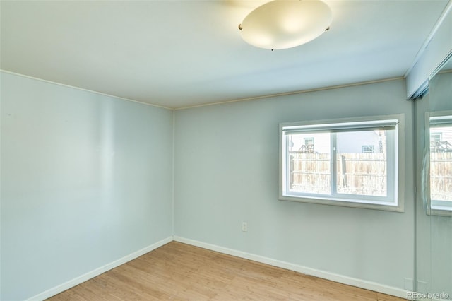 spare room featuring baseboards and wood finished floors