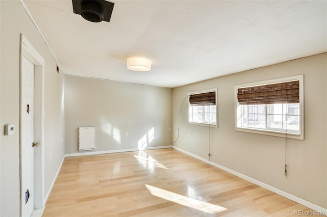 spare room featuring baseboards and light wood-style flooring