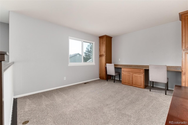 office area with light colored carpet and built in desk