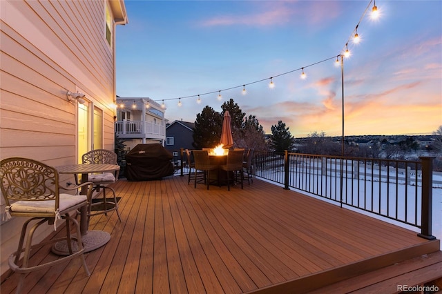 deck at dusk featuring area for grilling