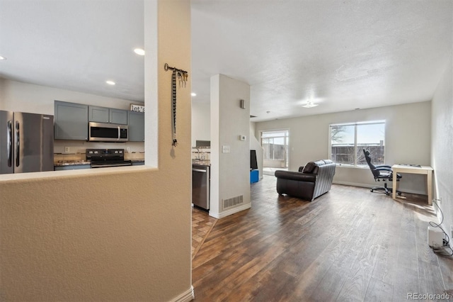 interior space featuring visible vents, appliances with stainless steel finishes, open floor plan, light countertops, and gray cabinetry